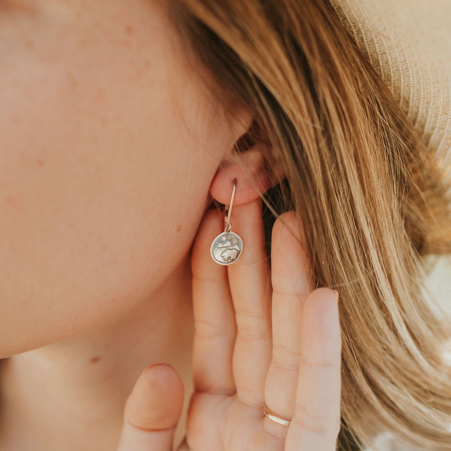 Girl wearing bear on mountain earrings in sterling silver