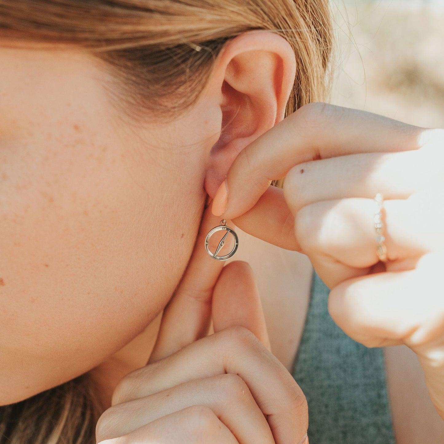 Girl wearing camping compass earrings in sterling silver