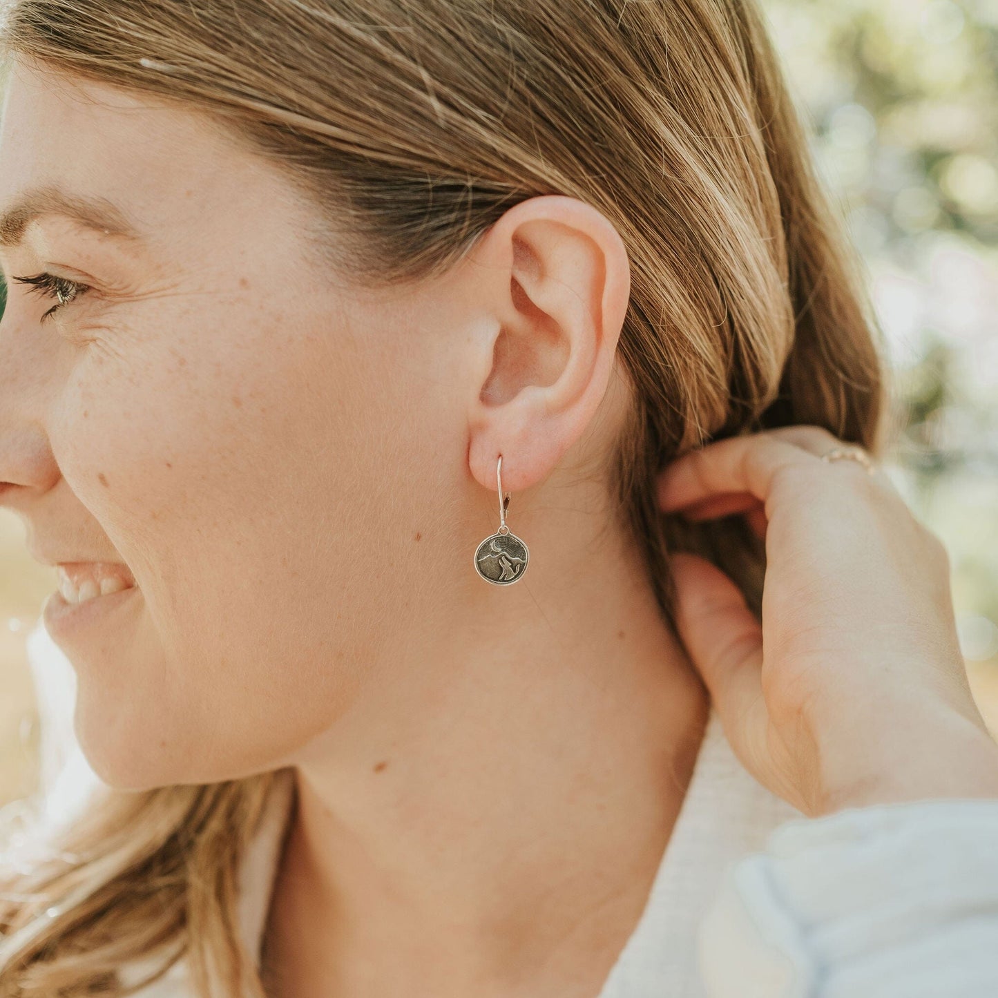 Girl wearing coyote howling at the moon earrings in sterling silver