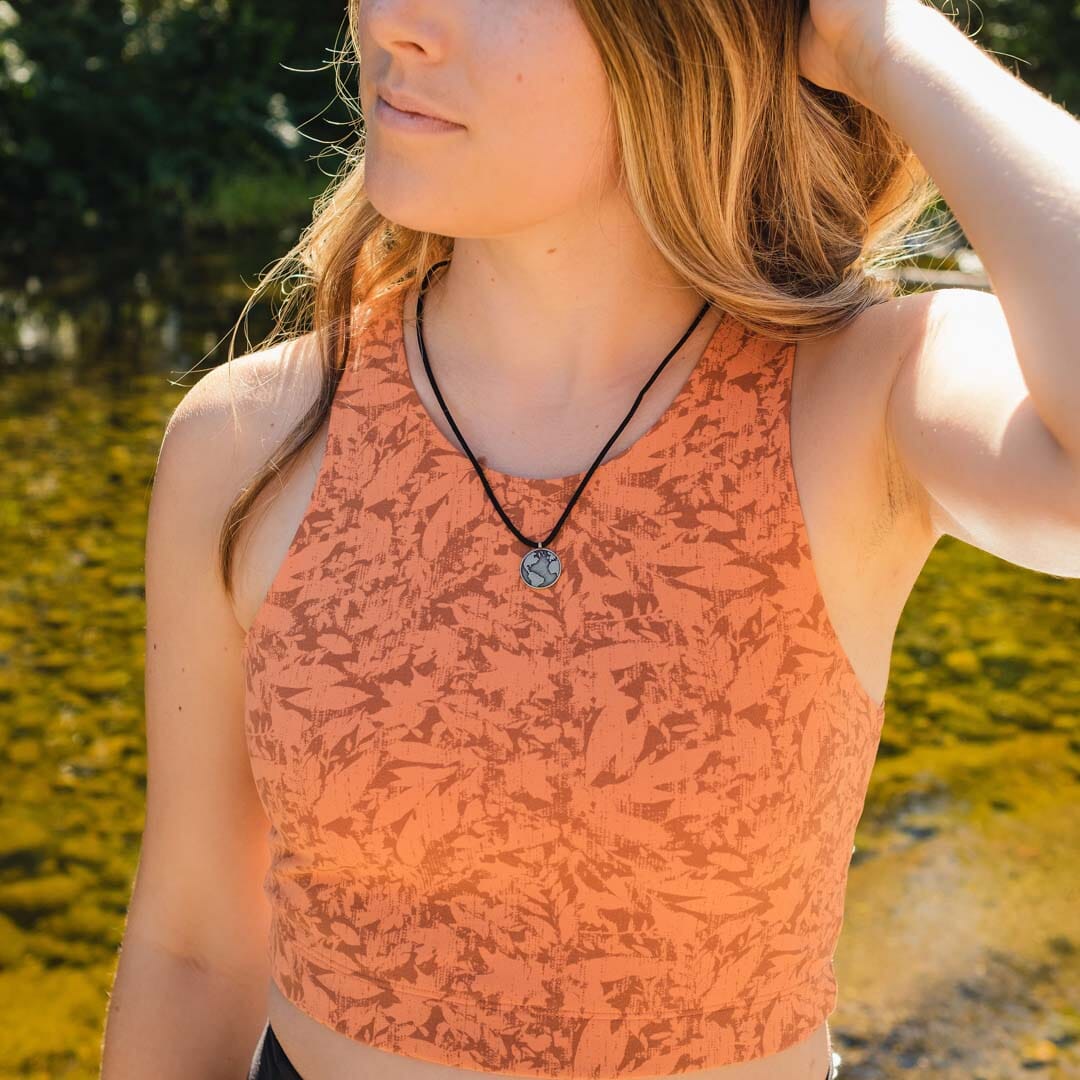 Women wearing white bronze globe pendant on black paracord