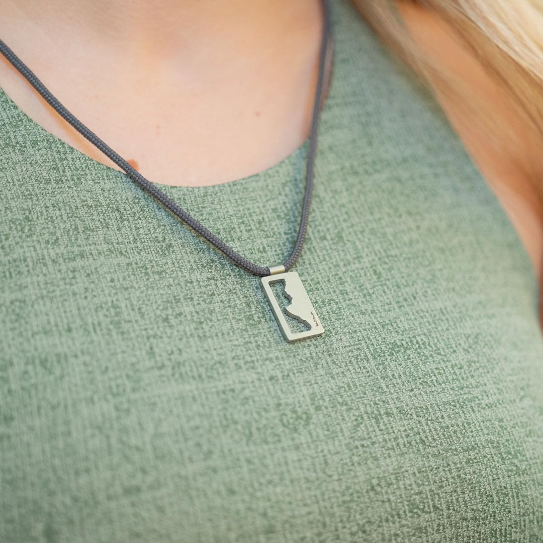 Women wearing stainless steel grand teton national park pendant on black paracord