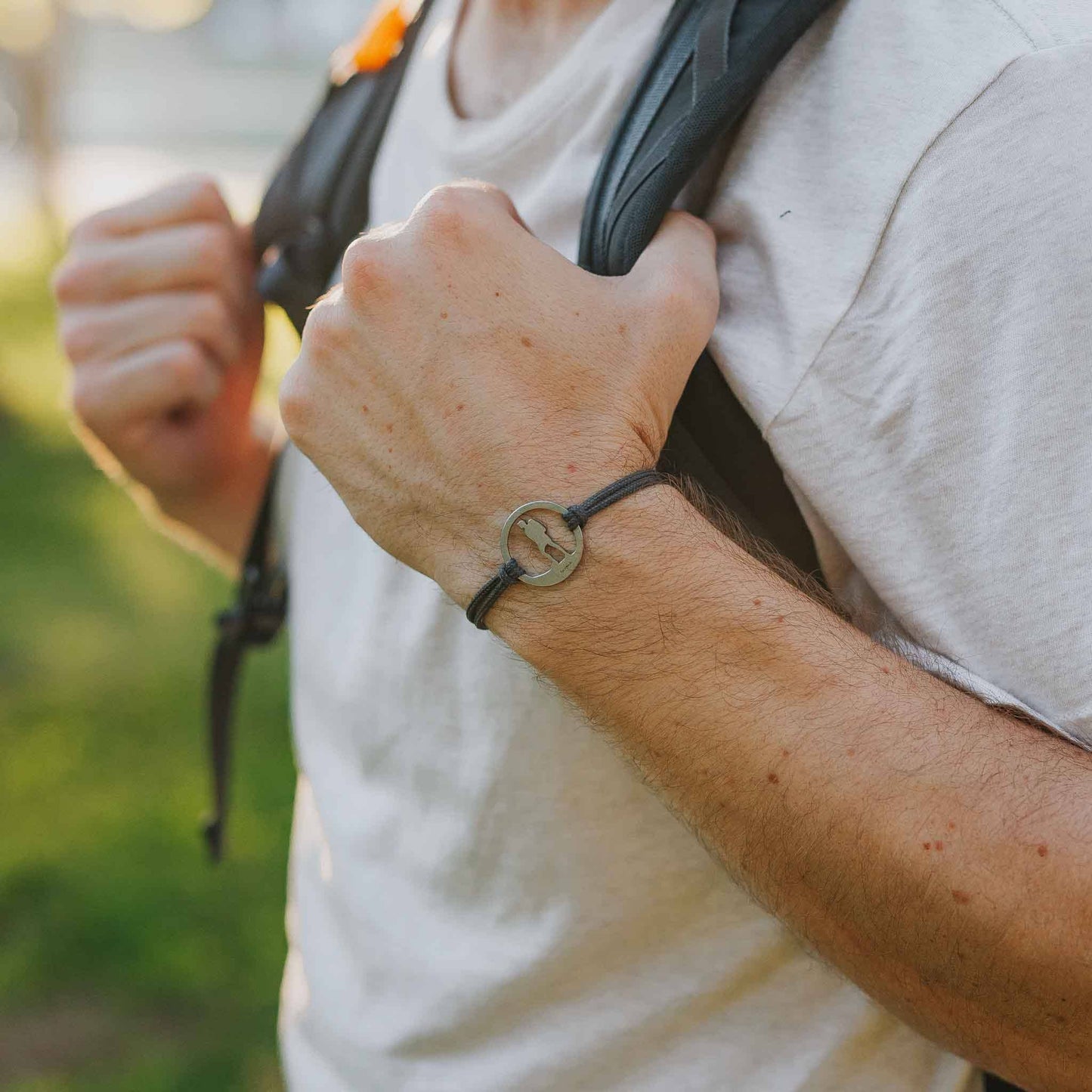 Man wearing stainless steel hiking guy bracelet on slate paracord