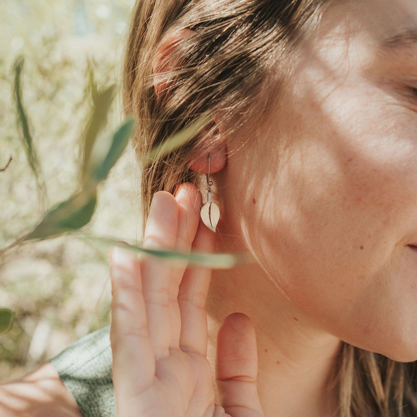 Girl wearing leaf earrings in stainless steel