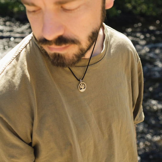 Man wearing stainless steel saguaro national park pendant on black paracord