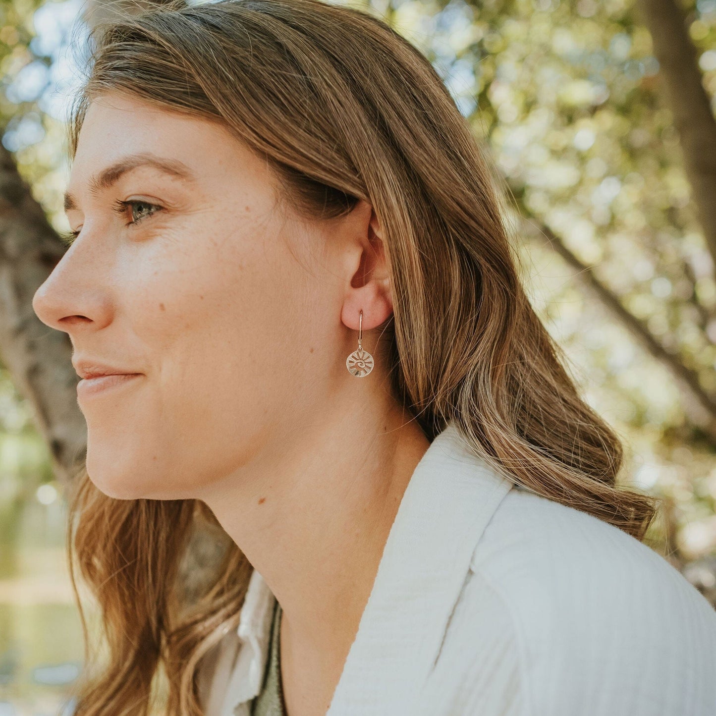 Girl wearing sun earrings in sterling silver