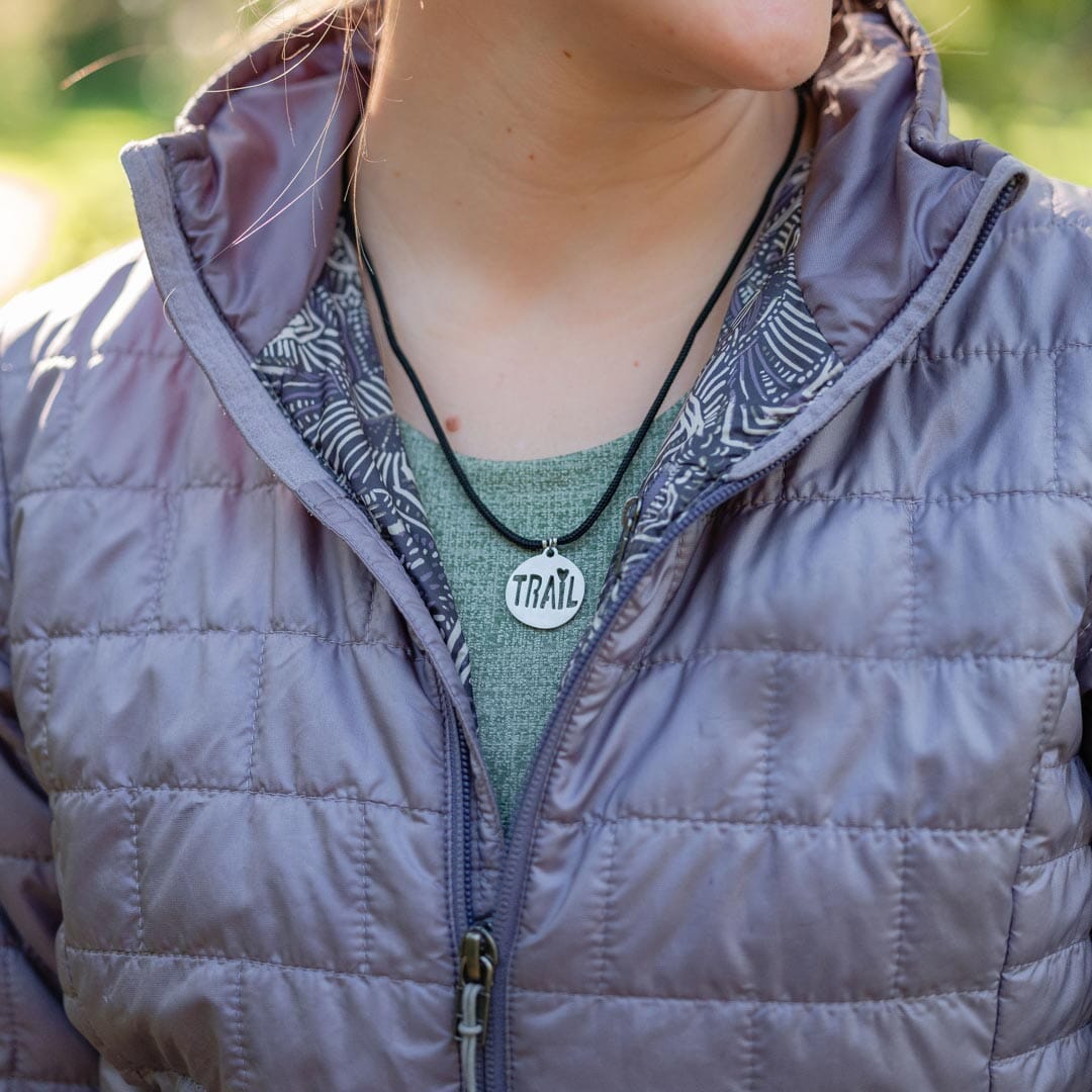 Women wearing stainless steel trail pendant on black paracord