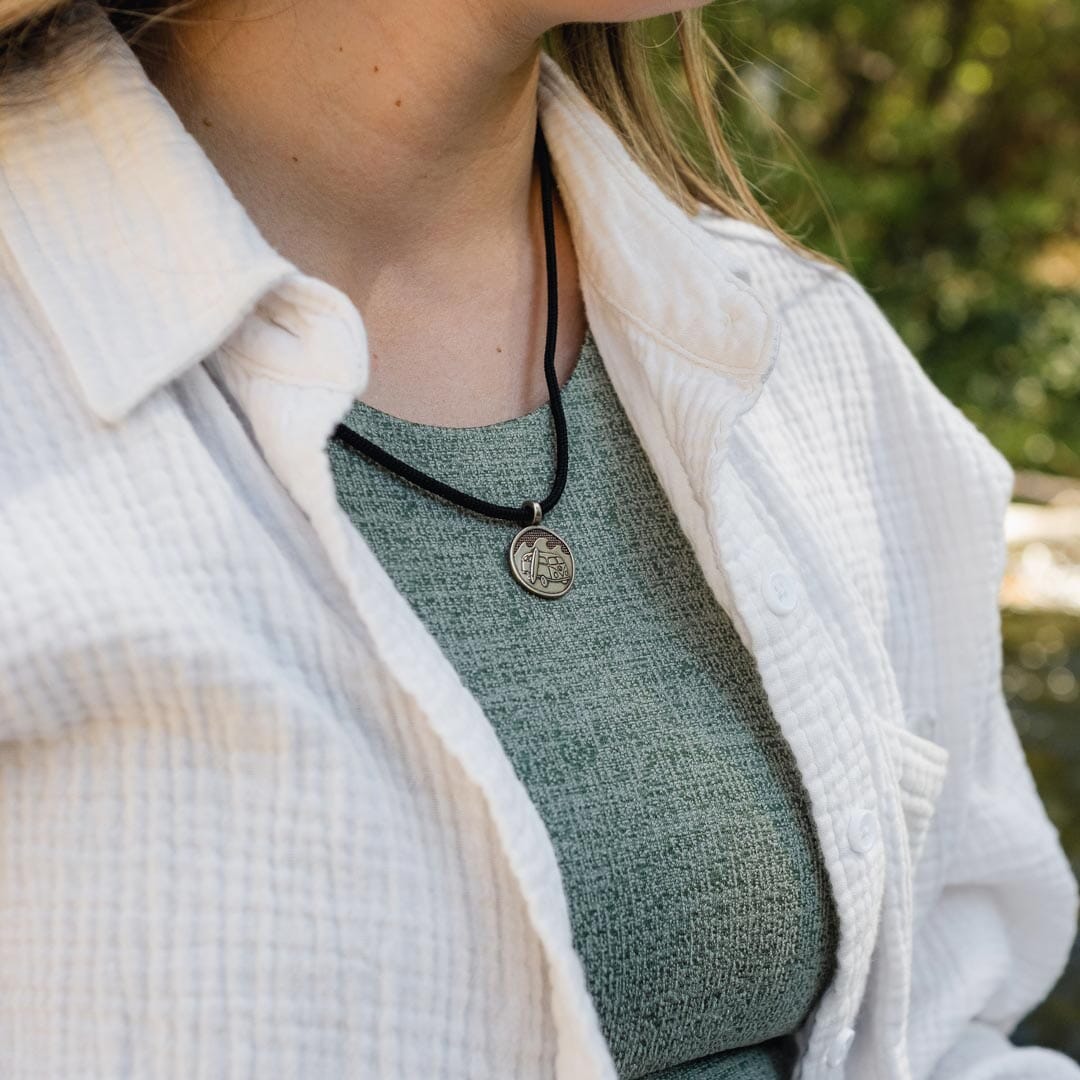 Women wearing white bronze van life pendant on black paracord