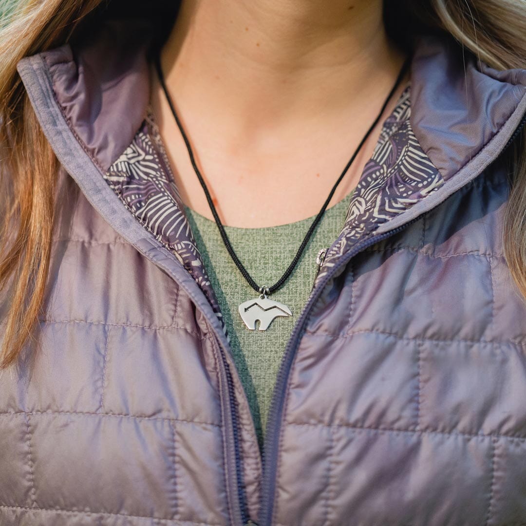Girl wearing stainless steel zuni bear pendant on black paracord