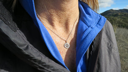 Sterling silver sun charm necklace worn on an 18-inch chain