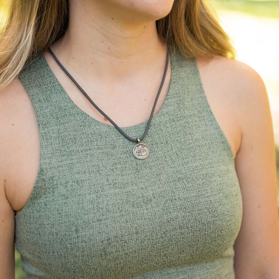 women wearing a bronze airstream camper van necklace on slate polycord