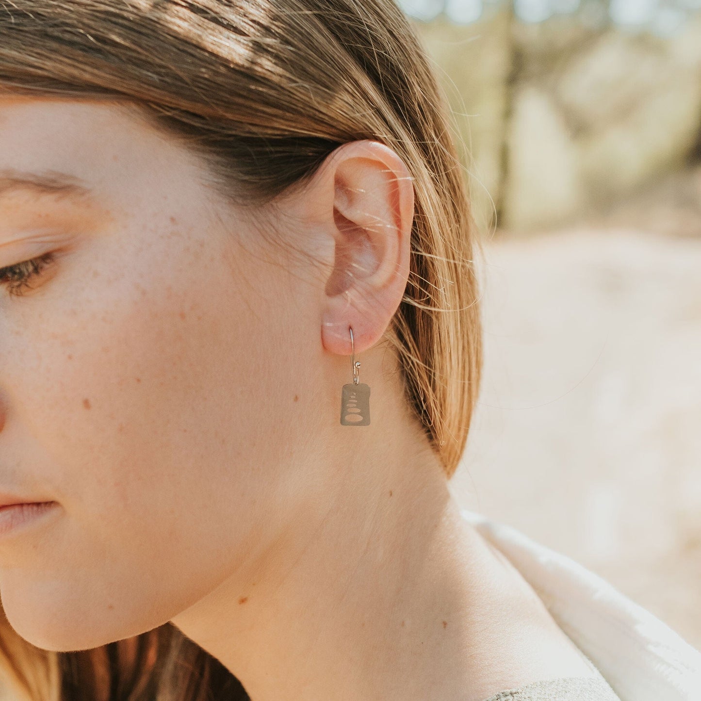 Girl wearing cairn stacked stone earrings in stainless steel