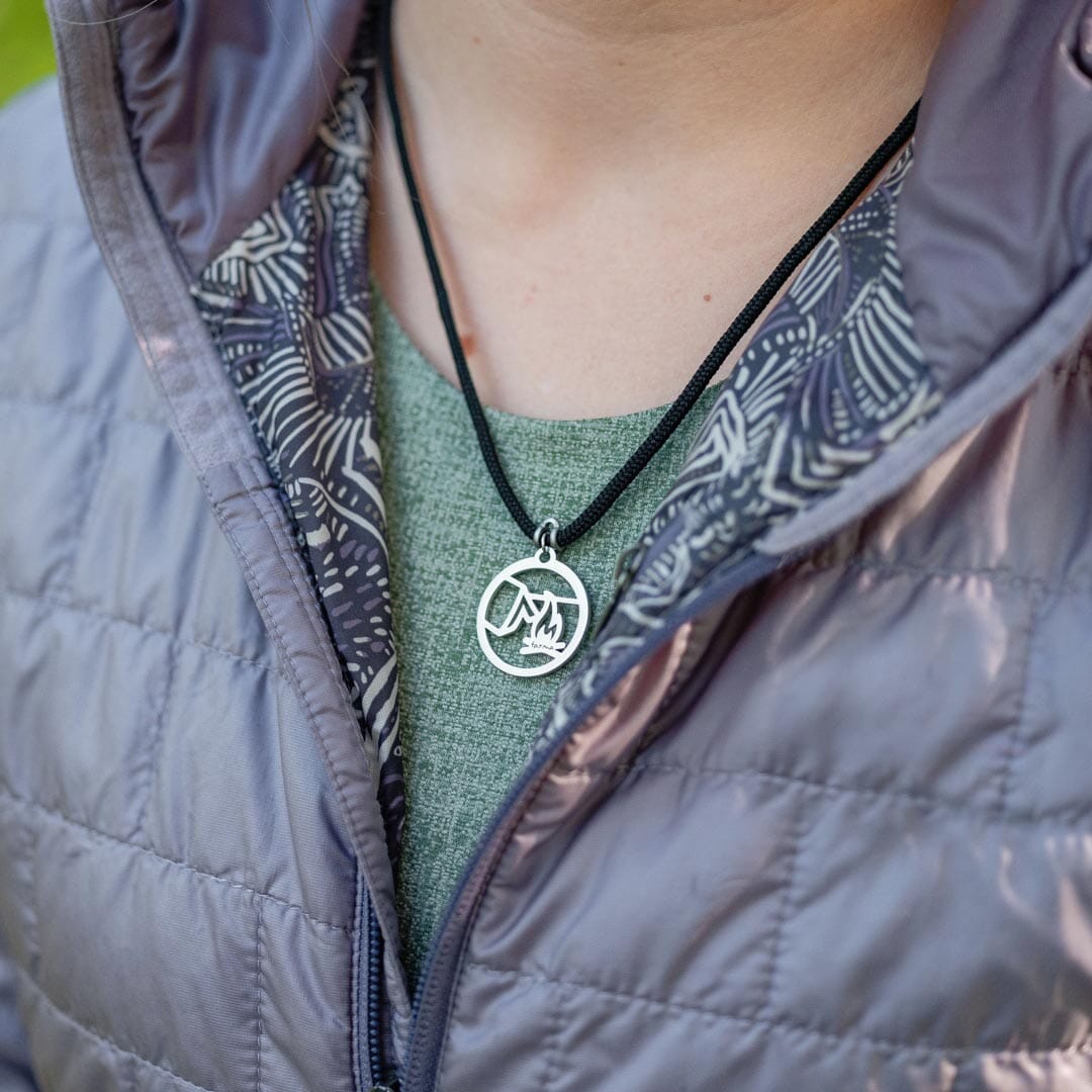 Women wearing stainless steel campfire pendant on black paracord
