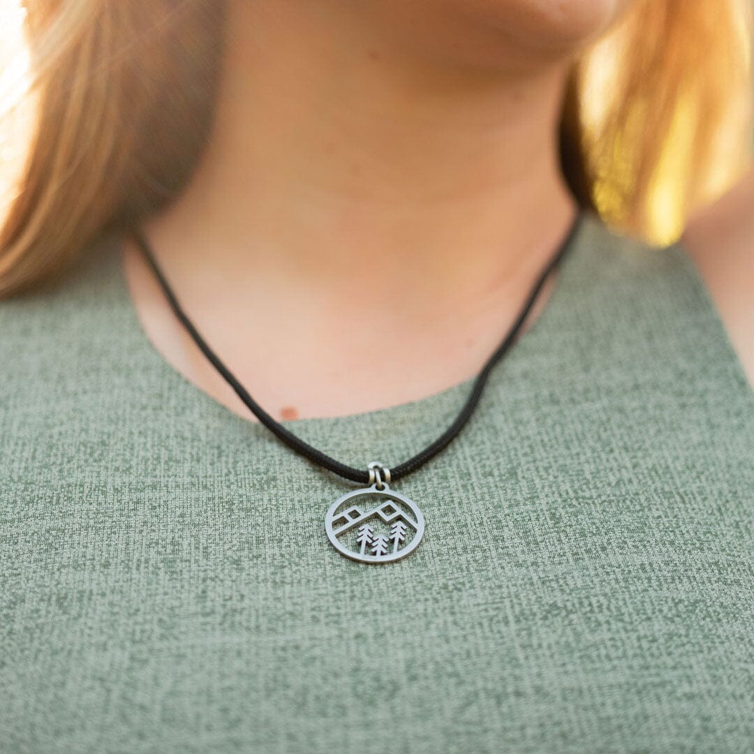 Women wearing stainless steel mountain pendant on black paracord