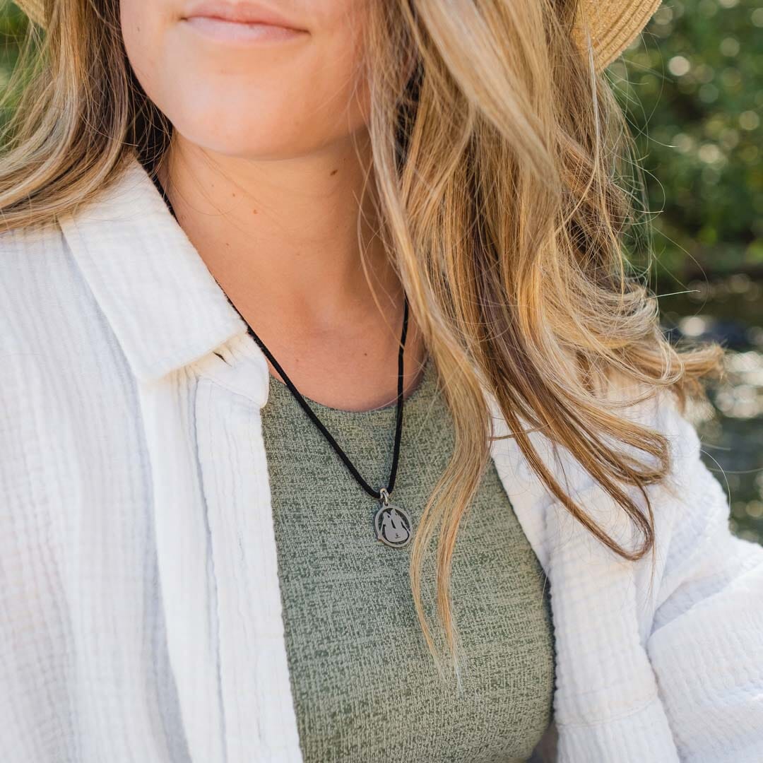 Women wearing stainless steel canoeing pendant on black paracord