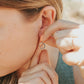 Girl wearing camping compass earrings in sterling silver 