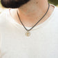Man wearing stainless steel grizzly bear paw pendant on black paracord