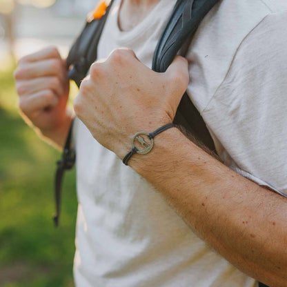 Man wearing stainless steel hiking guy bracelet on slate paracord