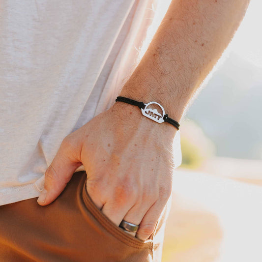 Man wearing stainless steel john muir trail bracelet on slate paracord