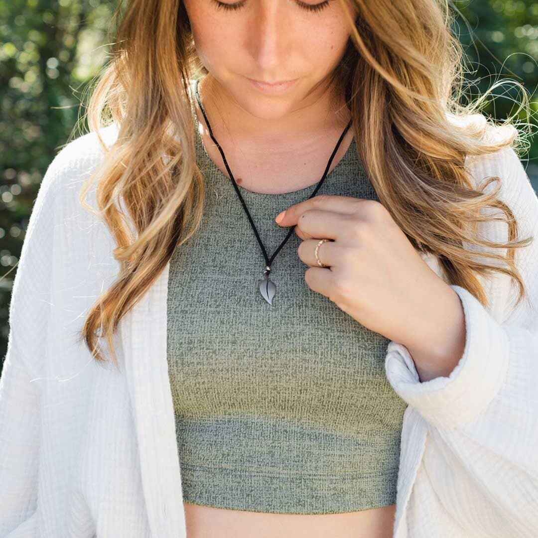 Girl wearing stainless steel leaf pendant on black paracord
