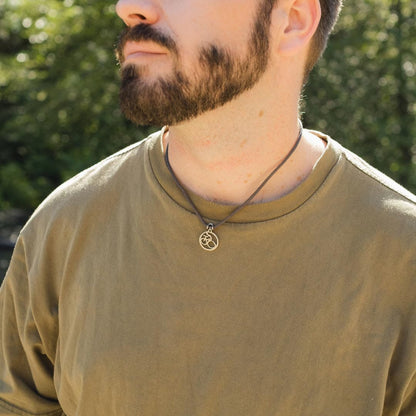 Man wearing stainless steel mountain bike pendant on slate paracord