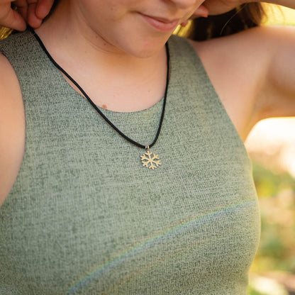 Women wearing stainless steel snowflake pendant on black paracord