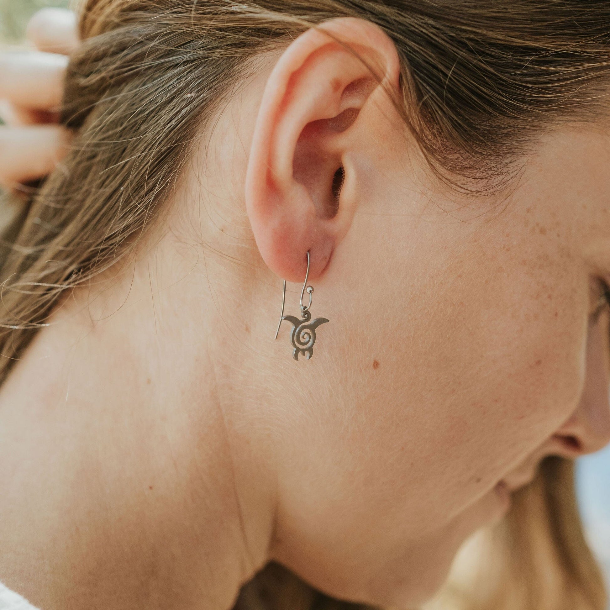 Girl wearing turtle earrings in stainless steel